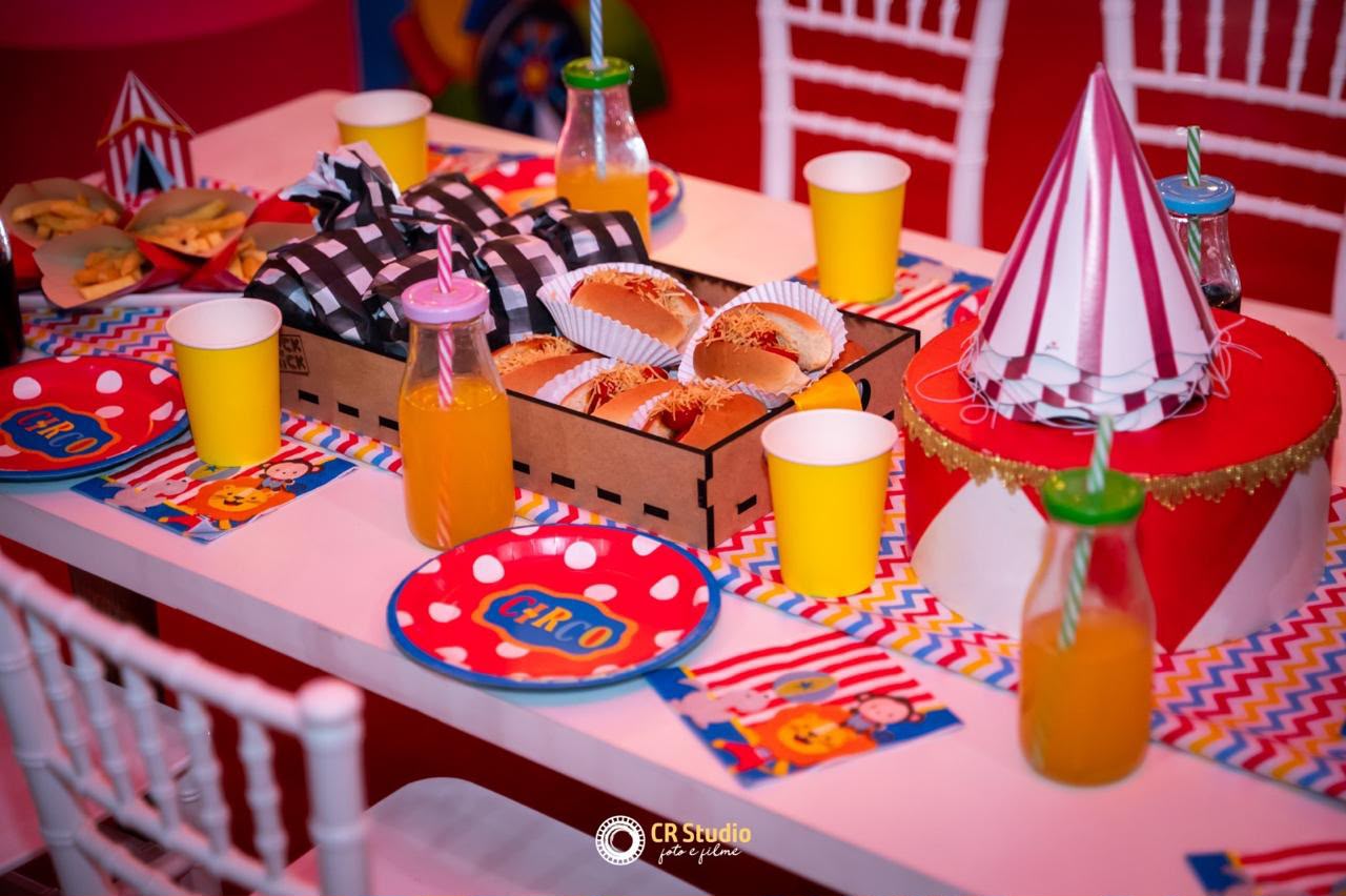 Mesa de festa com hot dogs e decoração circo