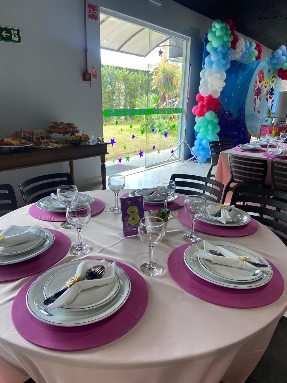 Mesa decorada com tema Baby Shark e arco de balões